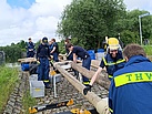 Die Bergungsgruppe des Technischen Zuges baut mit Rüstholz einen Tonnensteg.