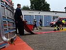 Neben den Geräten der FGr Öl bauen die Feuerwehrleute einen DEKON-Platz auf.
